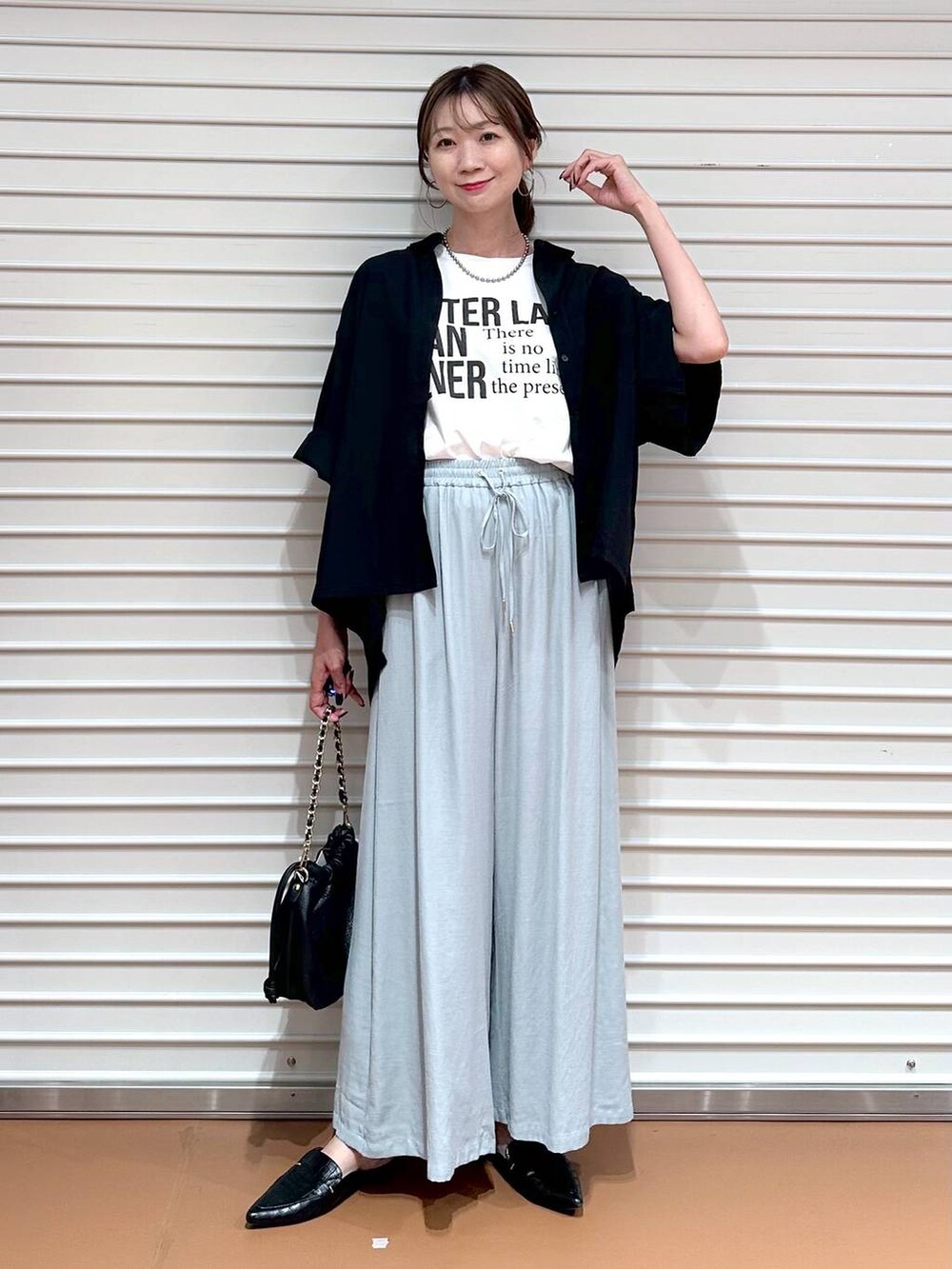 グリーン系のその他パンツ、ブラック系のハンドバッグ、ブラック系のシャツ/ブラウスを着用したレディースの夏コーディネートの3枚目の写真