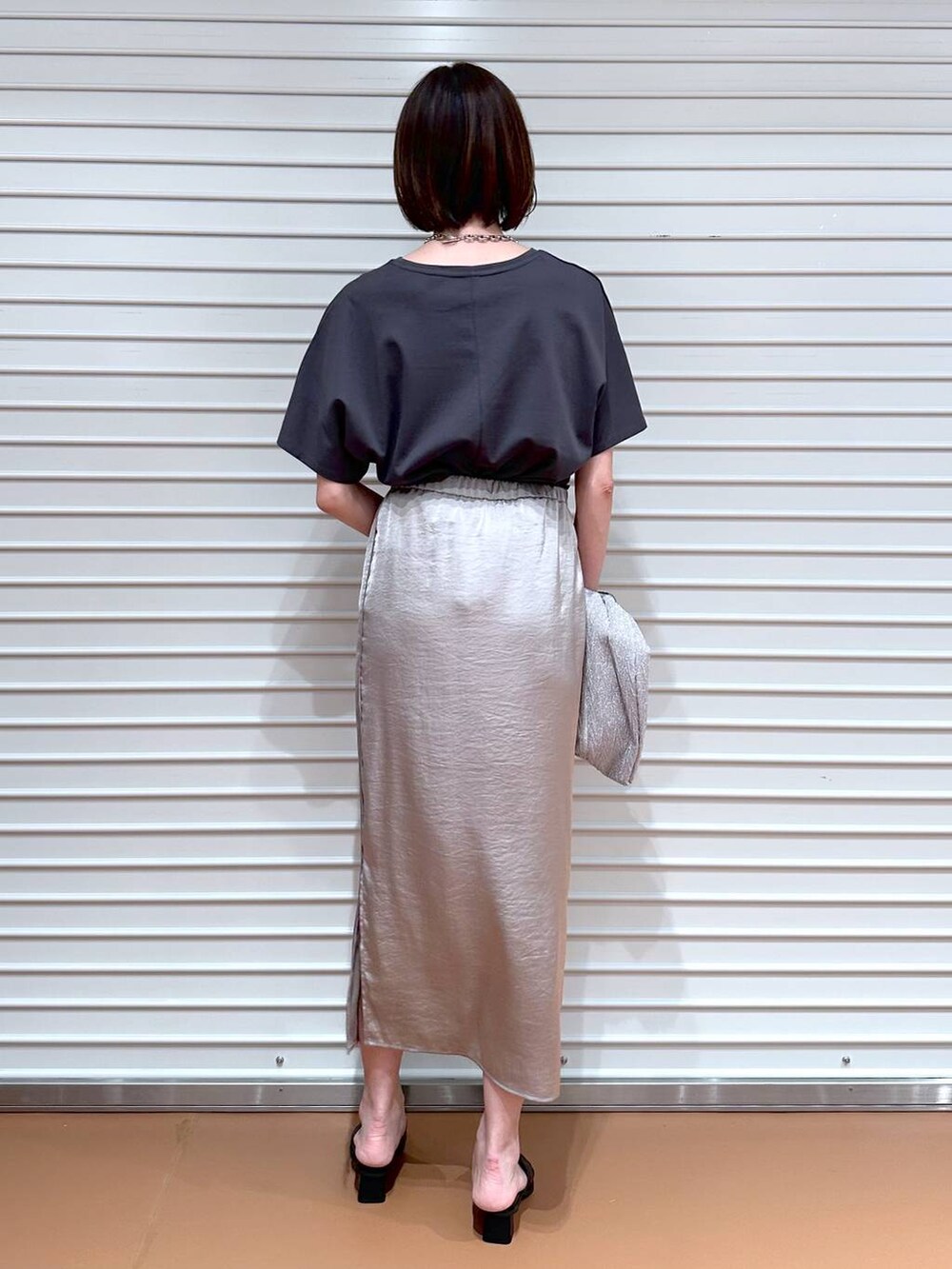 ベージュ系のスカート、ブラック系のサンダル、グレー系のTシャツ/カットソーを着用したレディースの春コーディネートの4枚目の写真