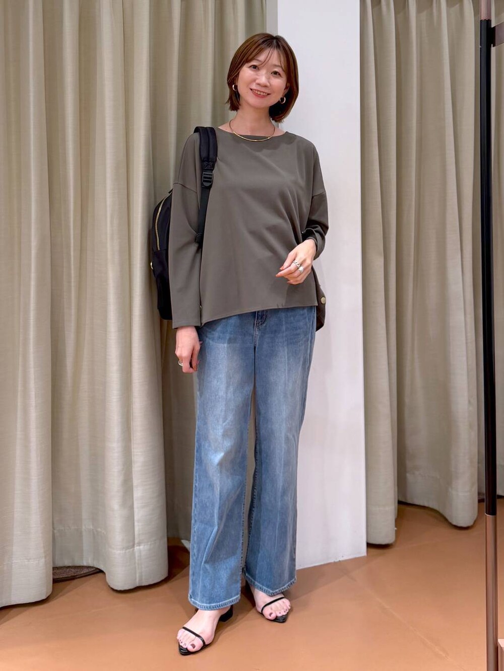 グリーン系のTシャツ/カットソー、ブラック系のバックパック/リュック、ブラック系のサンダルを着用したレディースの秋コーディネートの6枚目の写真