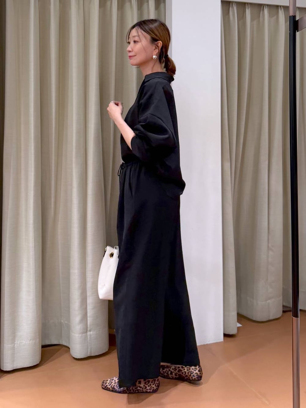 ブラウン系のパンプス、ホワイト系のトートバッグ、ブラック系のその他パンツを着用したレディースの冬コーディネートの5枚目の写真