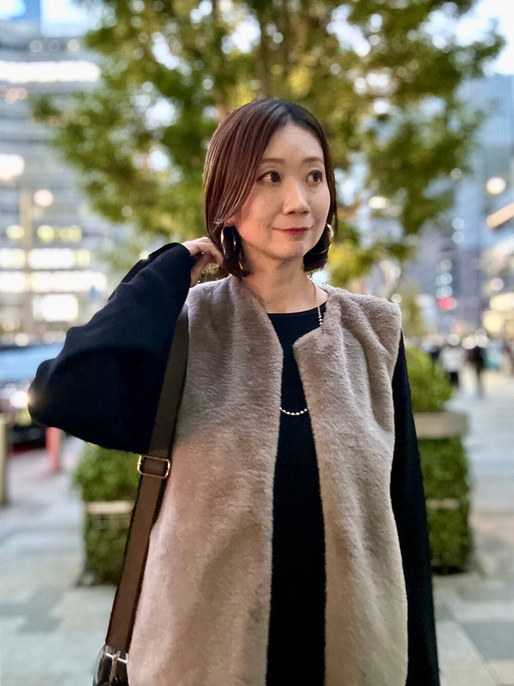 ブラック系のブーツ、ブラウン系のベスト、シルバー系のネックレスを着用したレディースの秋コーディネートの2枚目の写真