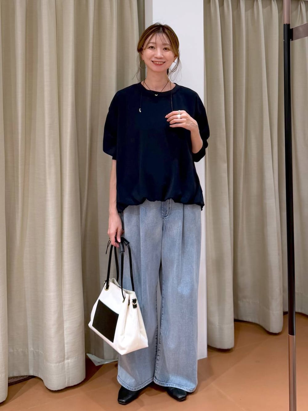 ホワイト系のパンプス、ブルー系のデニムパンツ、ホワイト系のトートバッグを着用したレディースの春コーディネートの6枚目の写真