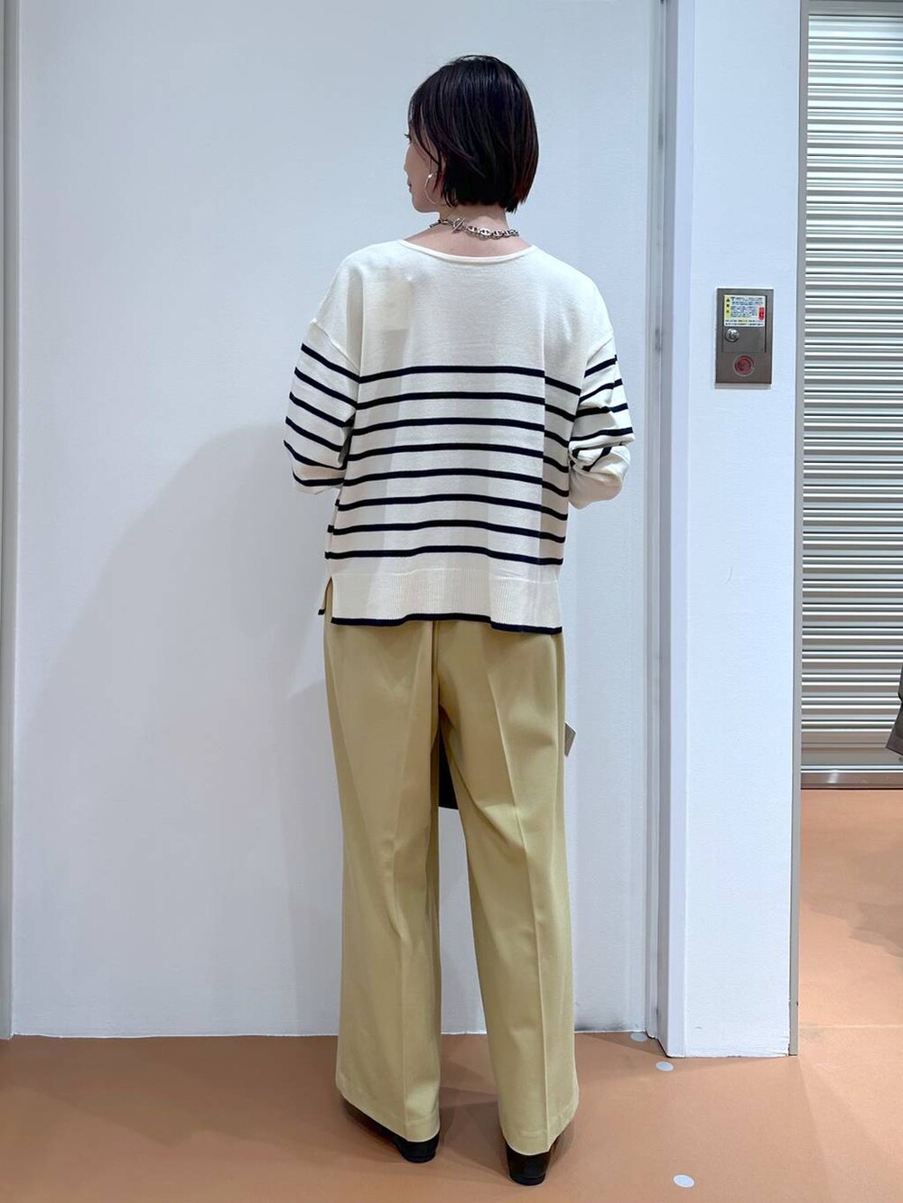 イエロー系のその他パンツ、ブルー系のニット/セーター、ブラック系のパンプスを着用したレディースの冬コーディネートの4枚目の写真