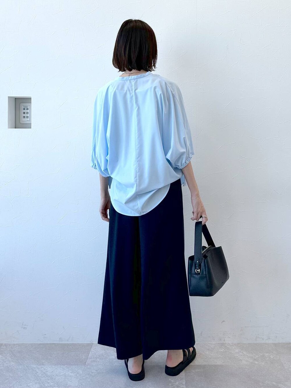 ブラック系のサンダル、ブルー系のシャツ/ブラウス、ブラック系のハンドバッグを着用したレディースの夏コーディネートの4枚目の写真