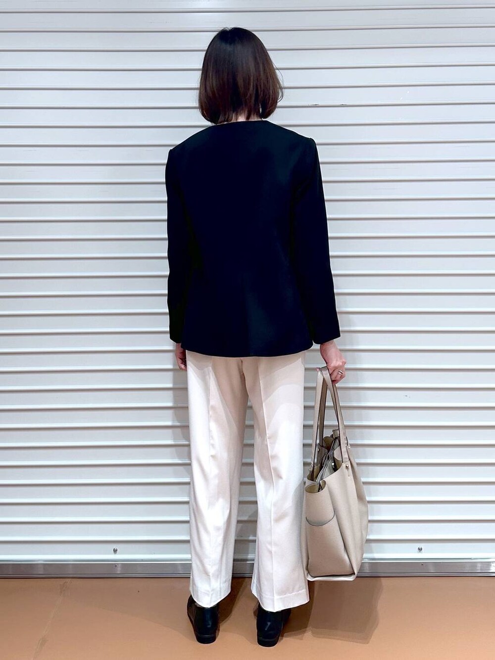 ブラック系のシャツ/ブラウス、ホワイト系のその他パンツ、ベージュ系のトートバッグを着用したレディースの春コーディネートの4枚目の写真
