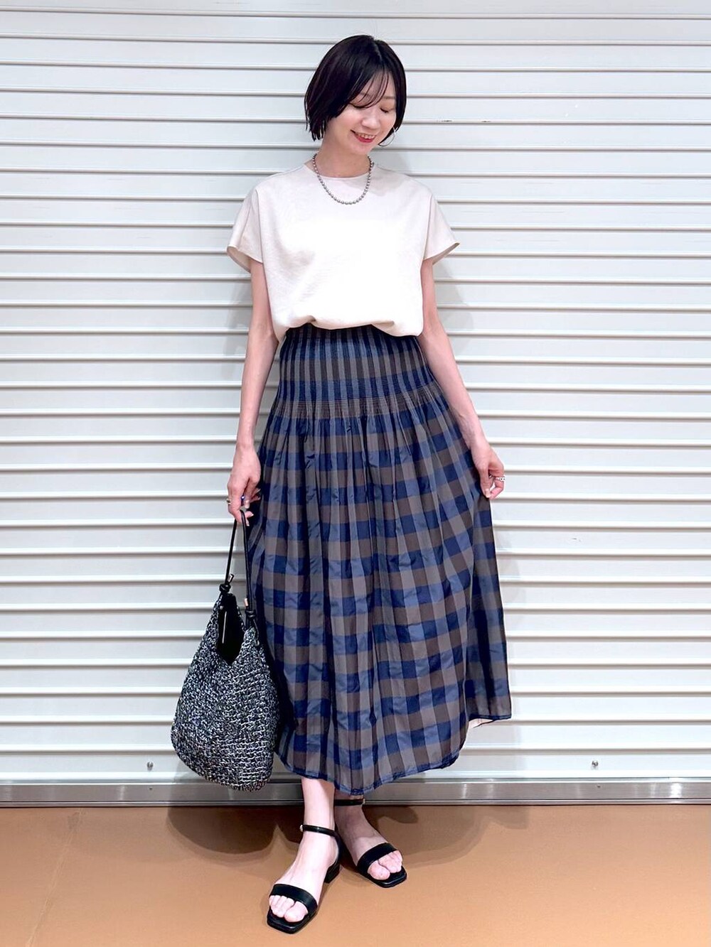 ベージュ系のシャツ/ブラウス、ブラウン系のスカート、ブラック系のサンダルを着用したレディースの夏コーディネートの2枚目の写真