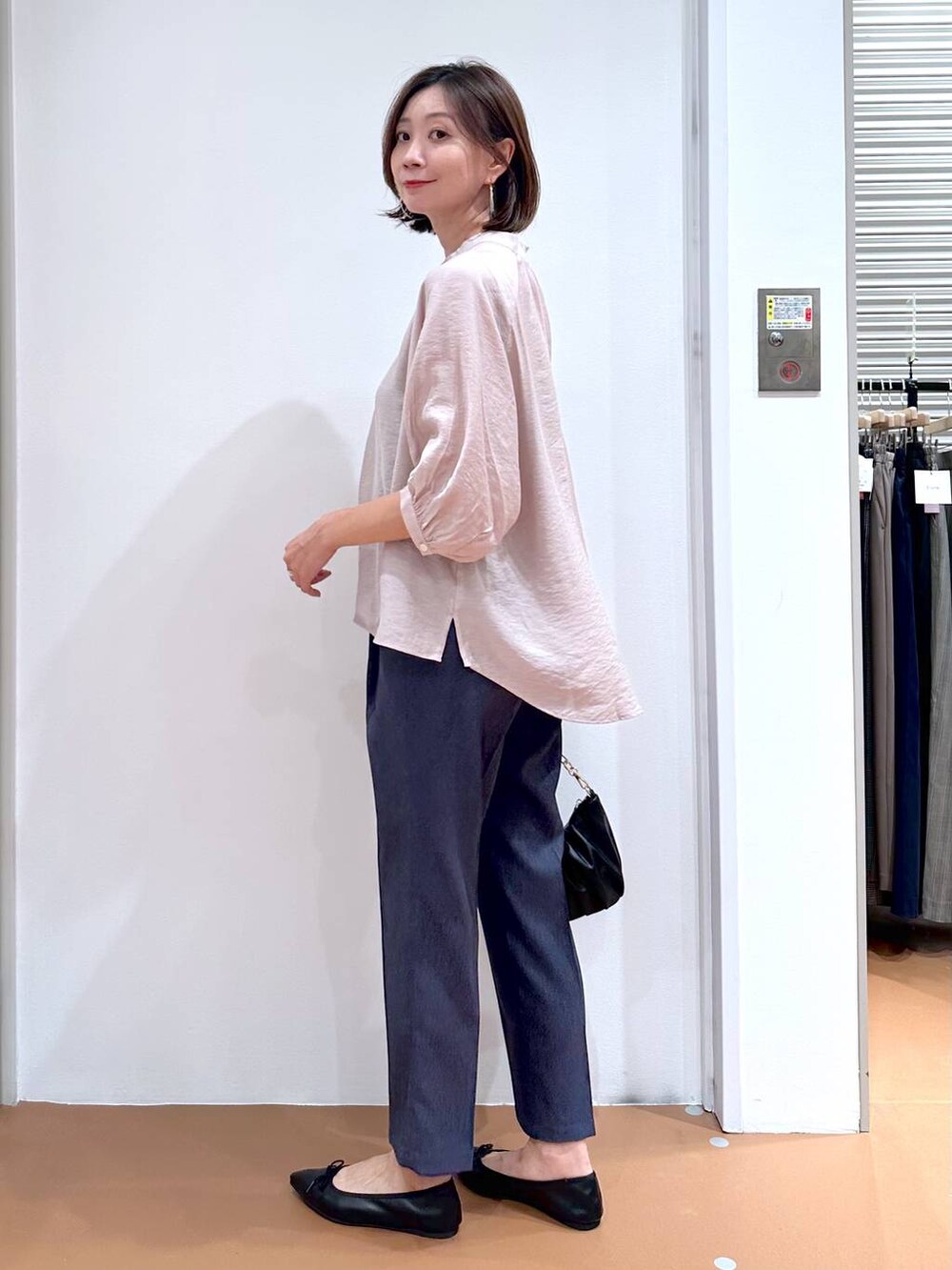 ベージュ系のシャツ/ブラウス、ブラック系のパンプス、ブルー系のデニムパンツを着用したレディースの秋コーディネートの3枚目の写真