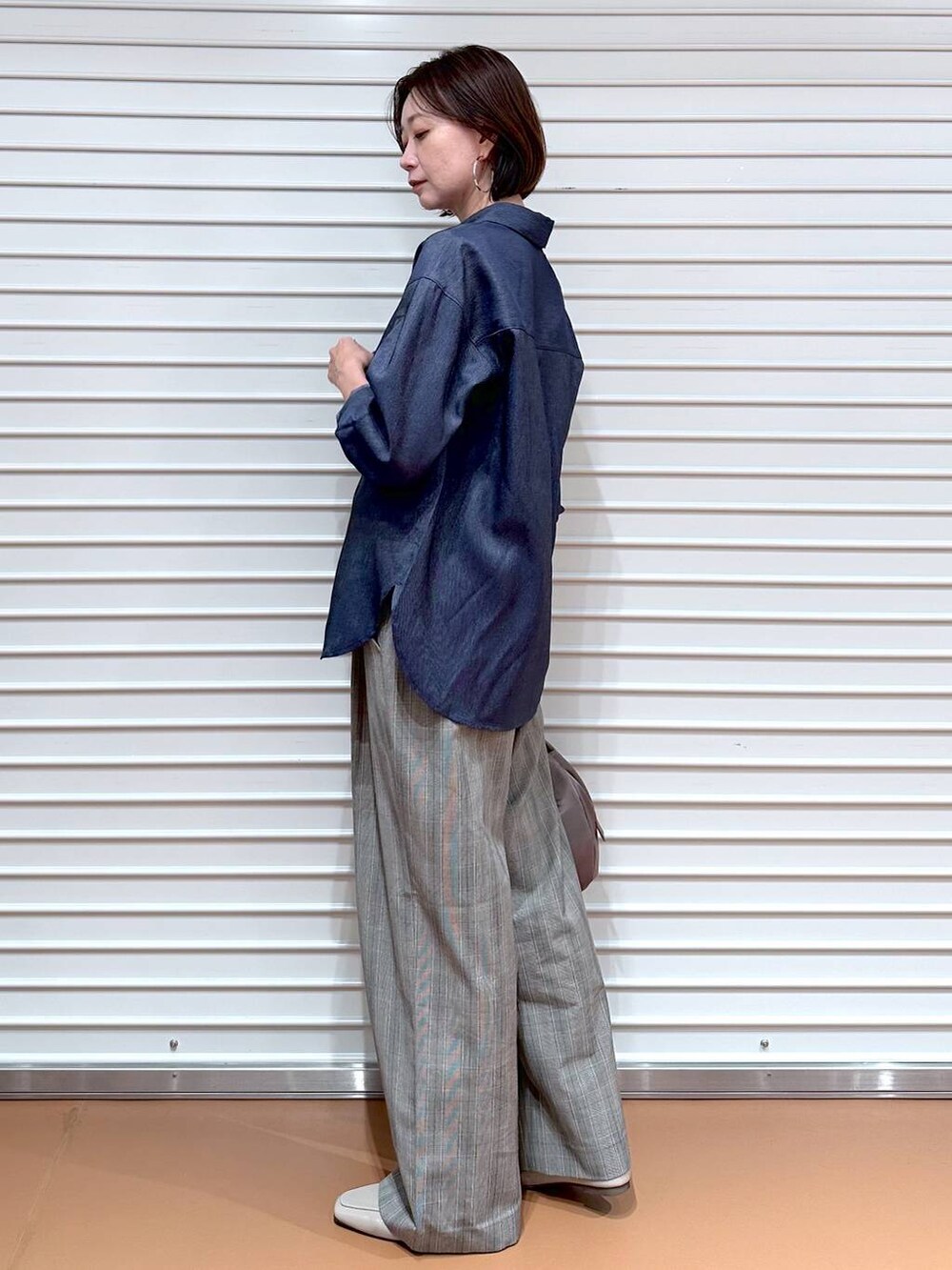 ブラウン系のその他パンツ、ベージュ系のハンドバッグ、ブラウン系のタンクトップを着用したレディースの秋コーディネートの3枚目の写真