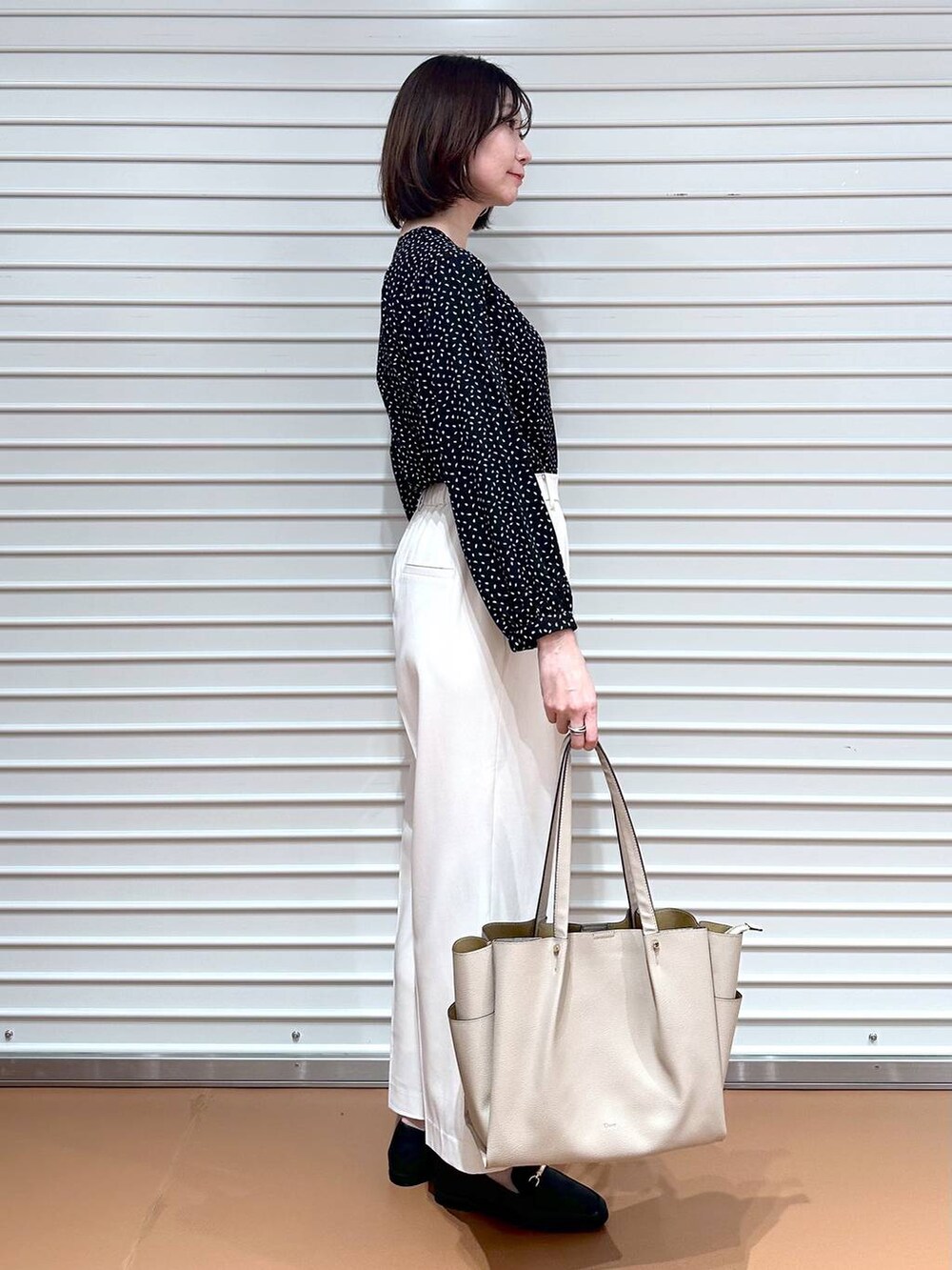 ブラック系のシャツ/ブラウス、ホワイト系のその他パンツ、ベージュ系のトートバッグを着用したレディースの春コーディネートの6枚目の写真