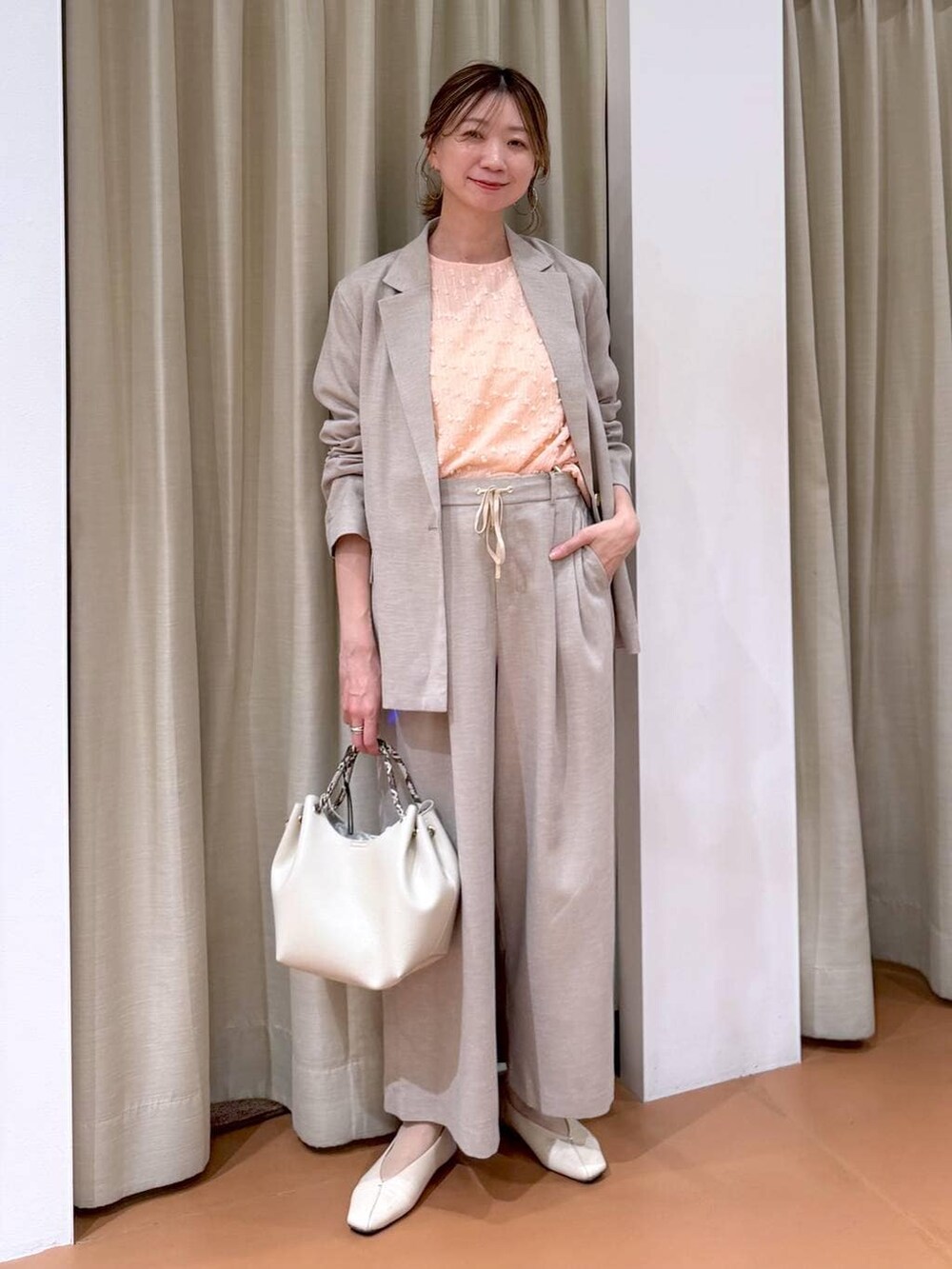 ホワイト系のパンプス、ホワイト系のハンドバッグ、ピンク系のシャツ/ブラウスを着用したレディースの春コーディネートの6枚目の写真