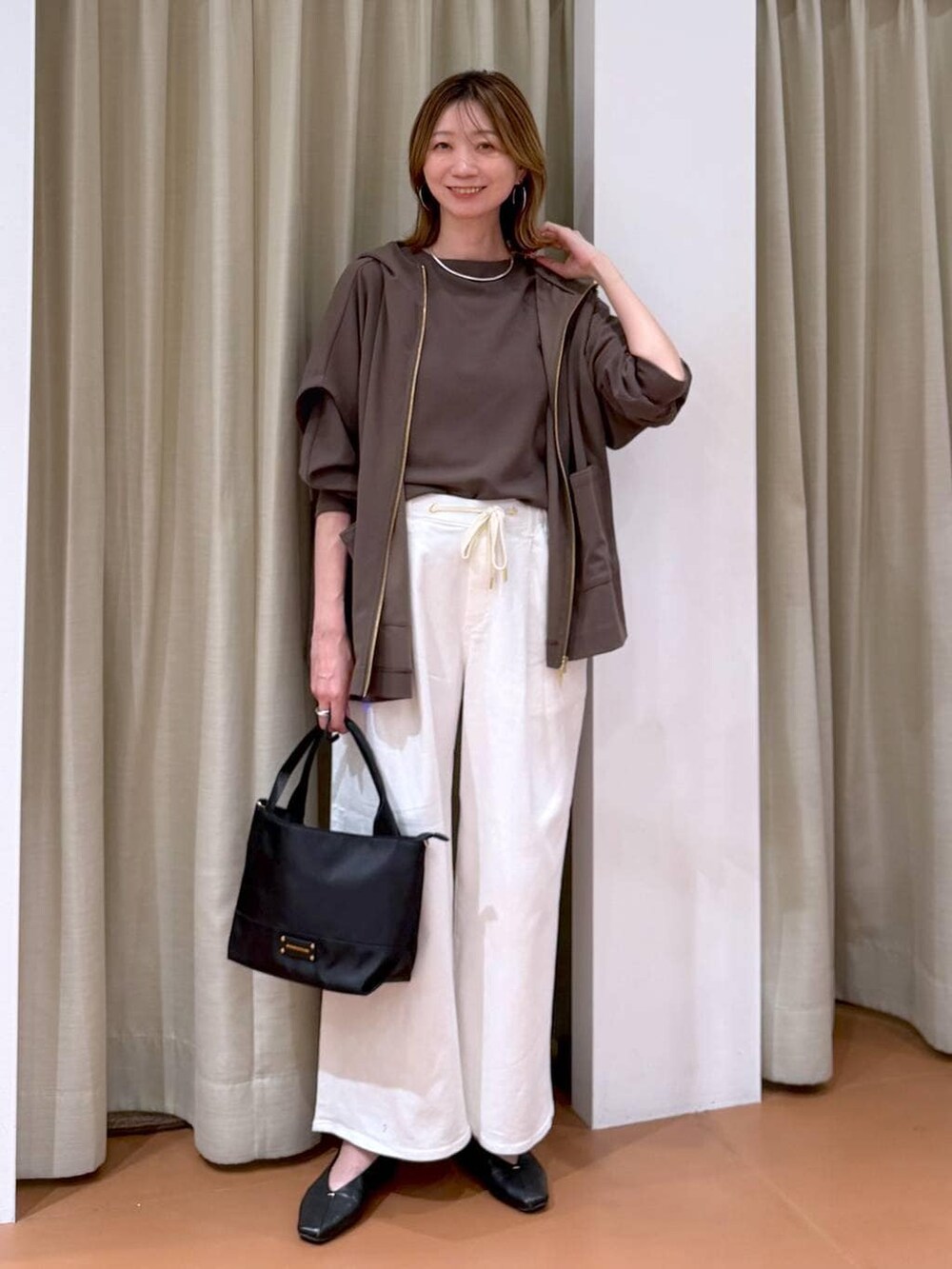 ブラック系のパンプス、ホワイト系のデニムパンツ、ブラウン系のTシャツ/カットソーを着用したレディースの春コーディネートの6枚目の写真