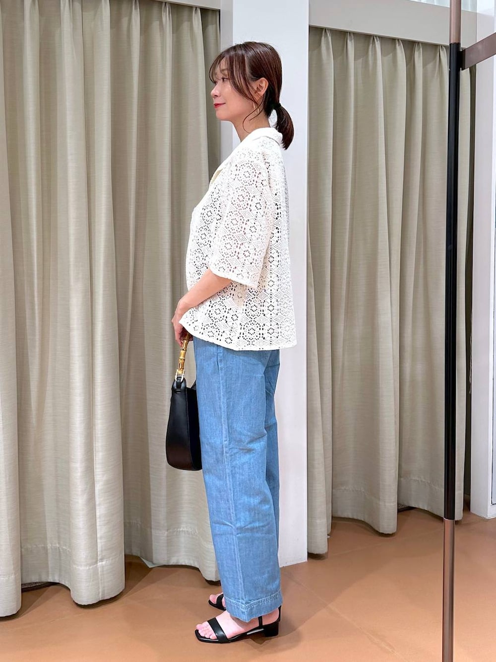 ブラック系のニット/セーター、ブルー系のデニムパンツ、ホワイト系のその他アウターを着用したレディースの夏コーディネートの3枚目の写真