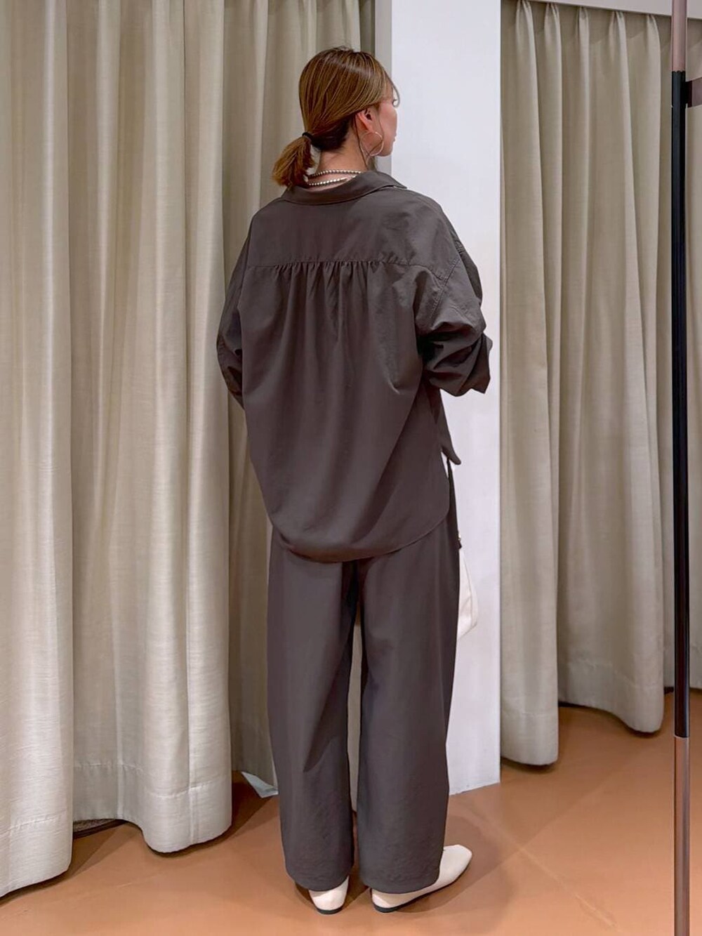 ホワイト系のパンプス、ブラック系のトートバッグ、ブラウン系のシャツ/ブラウスを着用したレディースの春コーディネートの4枚目の写真