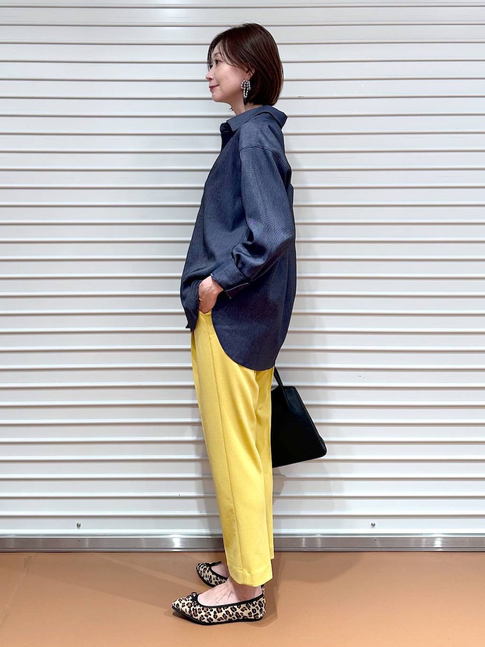 イエロー系のその他パンツ、ブラック系のハンドバッグ、ブラウン系のパンプスを着用したレディースの夏コーディネートの3枚目の写真