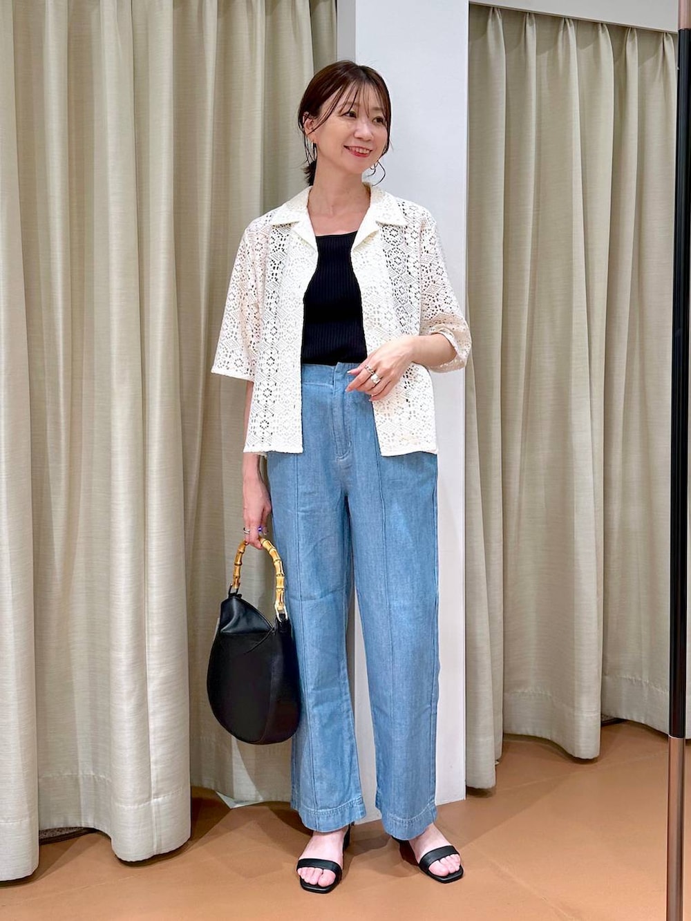 ブラック系のニット/セーター、ブルー系のデニムパンツ、ホワイト系のその他アウターを着用したレディースの夏コーディネートの2枚目の写真