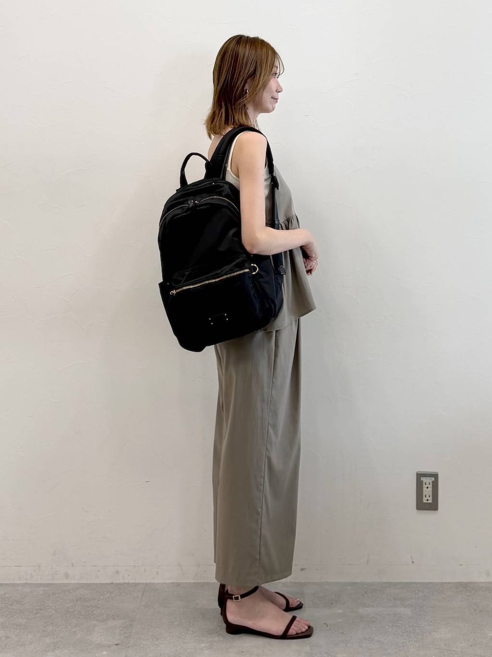 ブラック系のバックパック/リュック、グリーン系のその他パンツ、ブラウン系のサンダルを着用したレディースの秋コーディネートの5枚目の写真