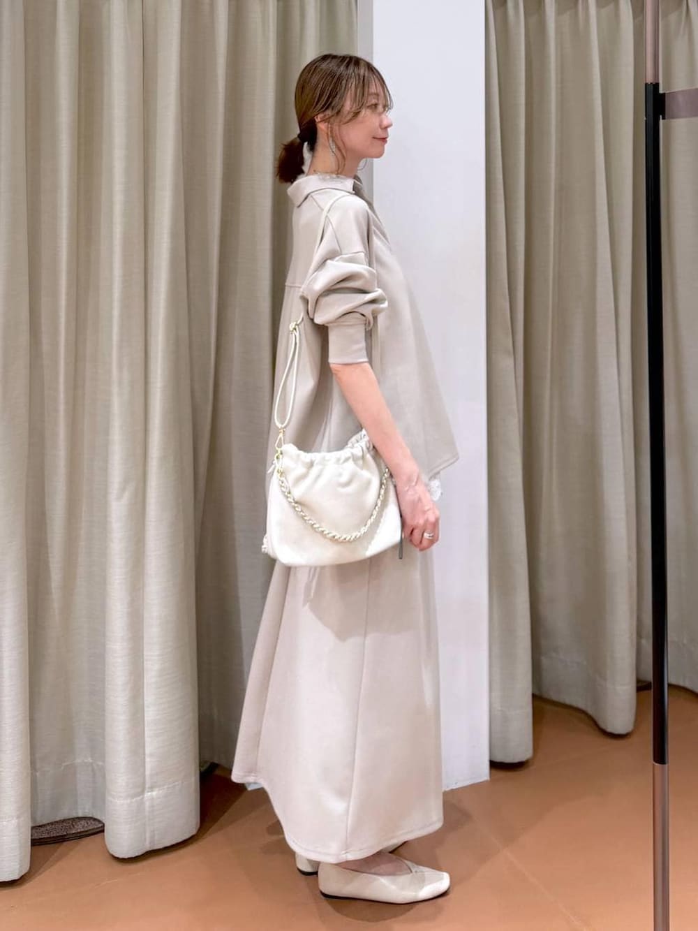 ホワイト系のハンドバッグ、ホワイト系のパンプス、ホワイト系のタンクトップを着用したレディースの冬コーディネートの5枚目の写真