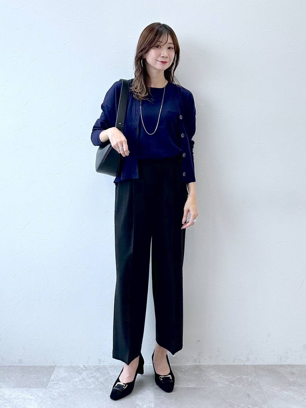グレー系のパンプス、ブルー系のその他パンツ、ブラック系のハンドバッグを着用したレディースの冬コーディネートの2枚目の写真
