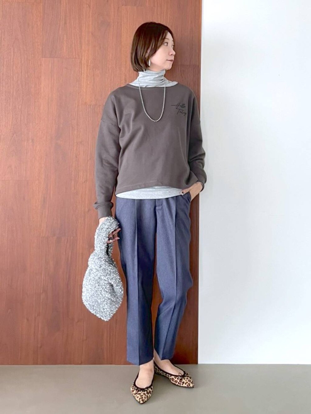 ブラウン系のパンプス、ブルー系のデニムパンツ、シルバー系のネックレスを着用したレディースの夏コーディネートの2枚目の写真