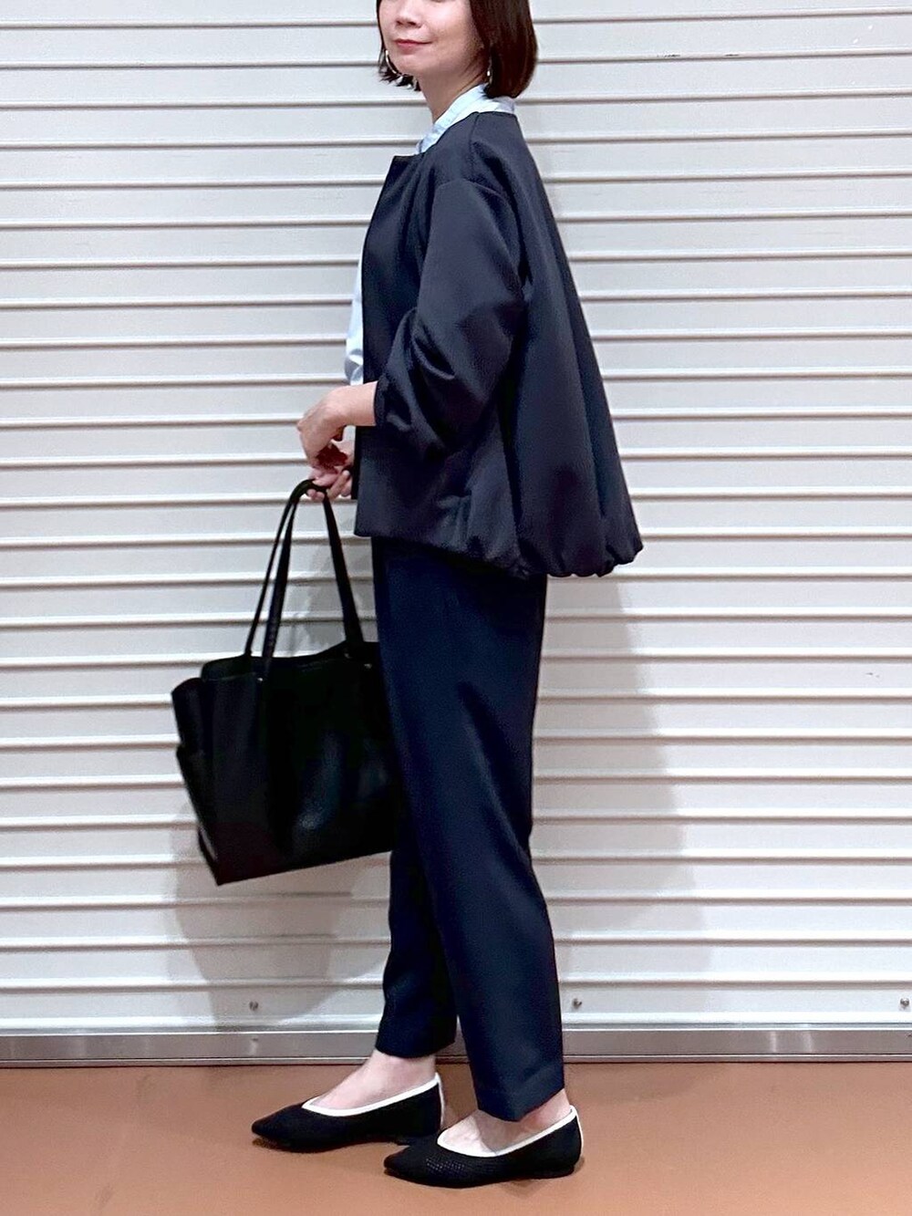 ブラック系のパンプス、ブラック系のトートバッグ、ブルー系のその他パンツを着用したレディースの春コーディネートの7枚目の写真