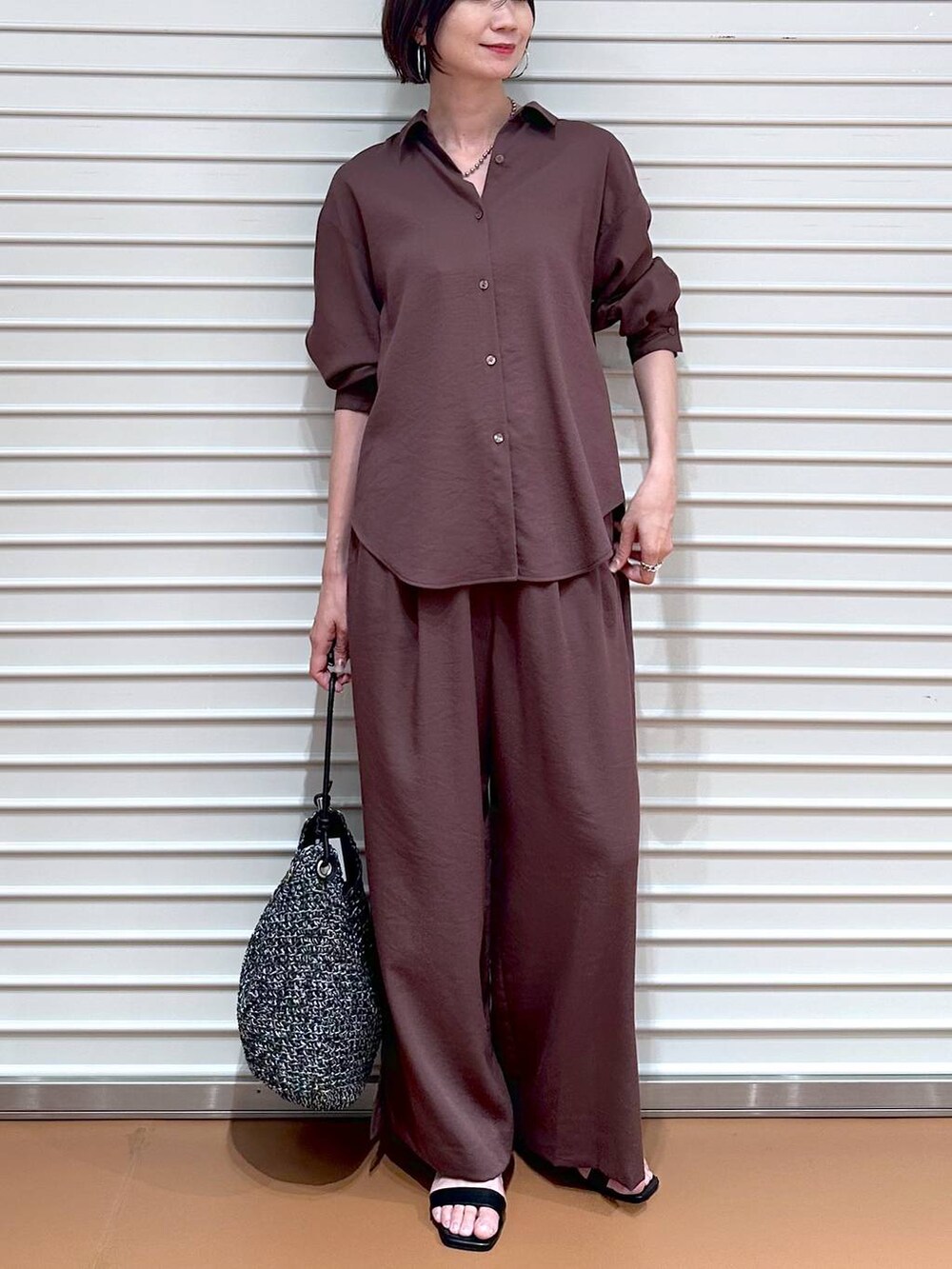 ブラウン系のシャツ/ブラウス、ブラウン系のその他パンツ、ブラック系のサンダルを着用したレディースの夏コーディネートの5枚目の写真