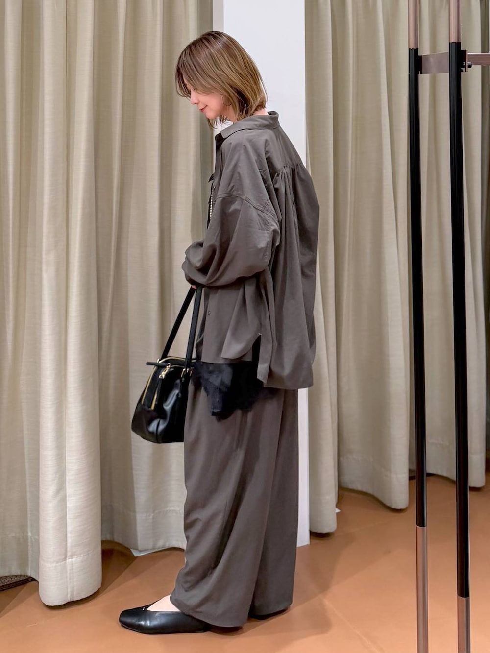 ブラック系のパンプス、ブラック系のキャミソール、ブラック系のボストンバッグを着用したレディースの春コーディネートの3枚目の写真