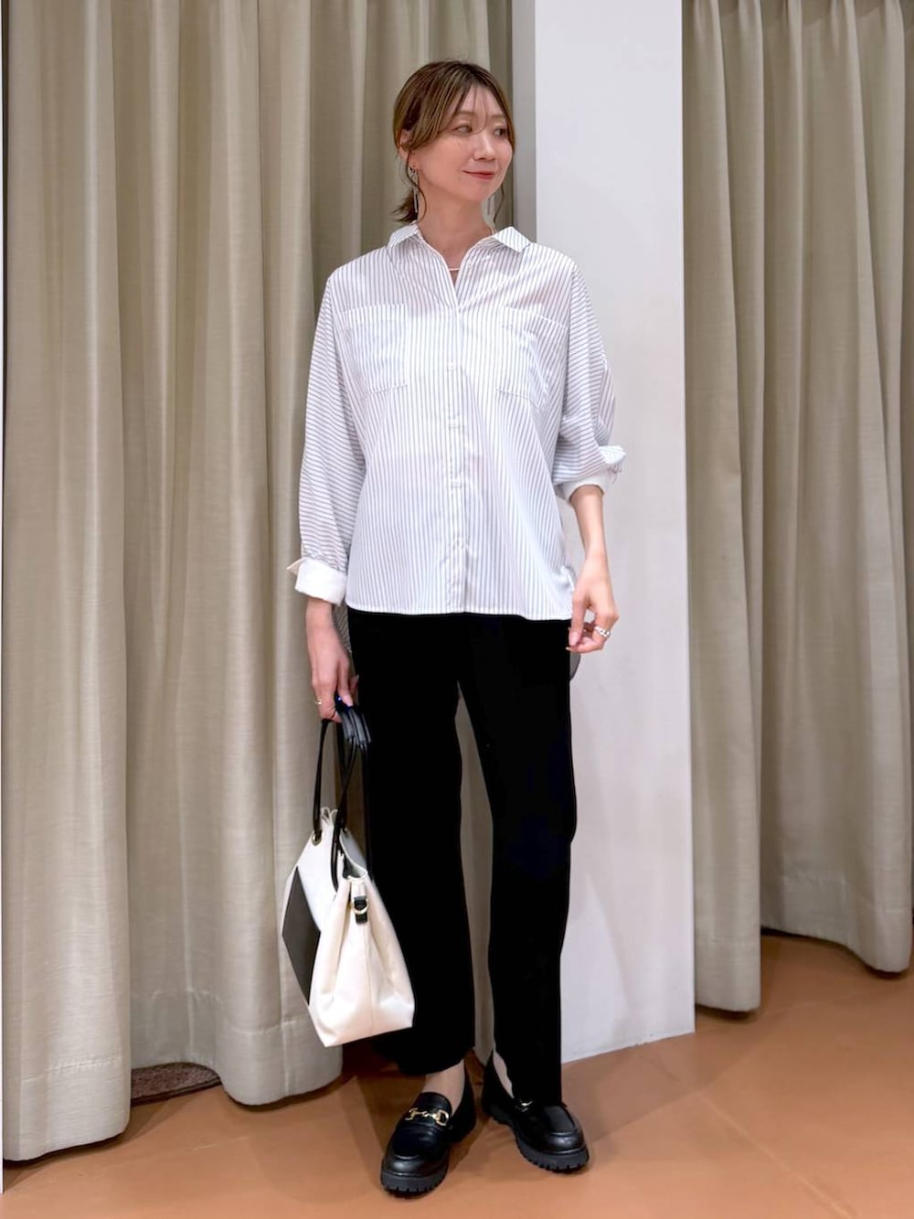 ブラック系のローファー、ホワイト系のトートバッグ、ホワイト系のシャツ/ブラウスを着用したレディースの春コーディネートの6枚目の写真