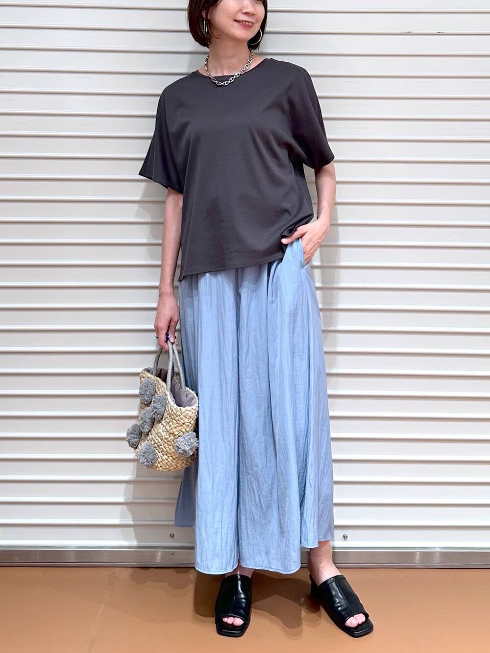 グレー系のTシャツ/カットソー、ブラック系のサンダル、ブルー系のその他パンツを着用したレディースの夏コーディネートの6枚目の写真