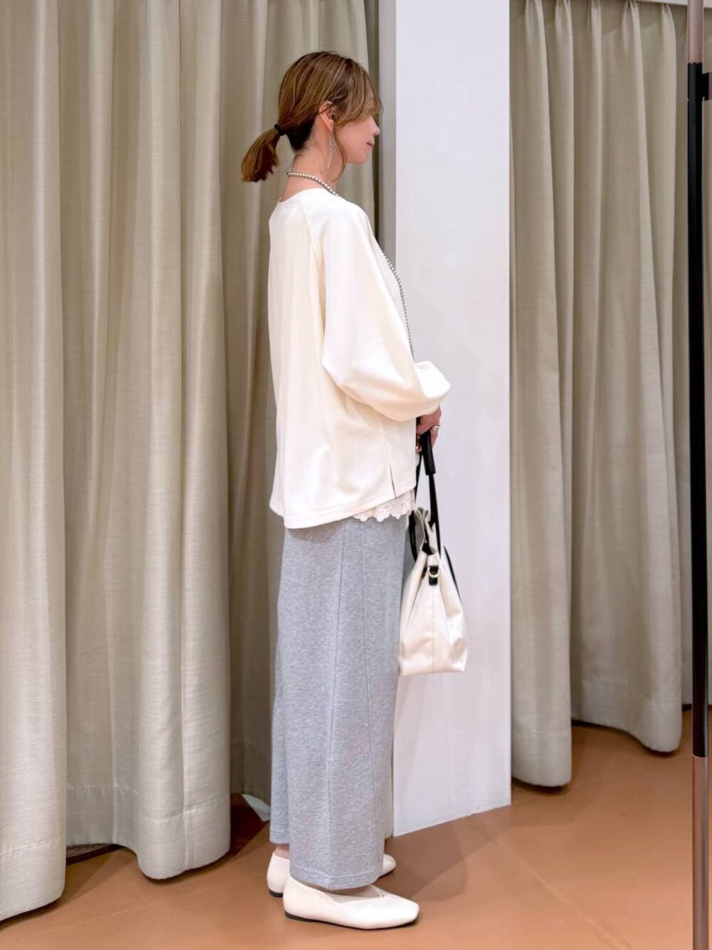 ホワイト系のパンプス、ホワイト系のタンクトップ、グレー系のスウェットパンツを着用したレディースの春コーディネートの5枚目の写真