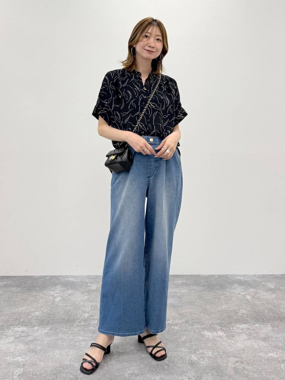 ブルー系のシャツ/ブラウス、ブラック系のショルダーバッグを着用したレディースの春コーディネートの2枚目の写真