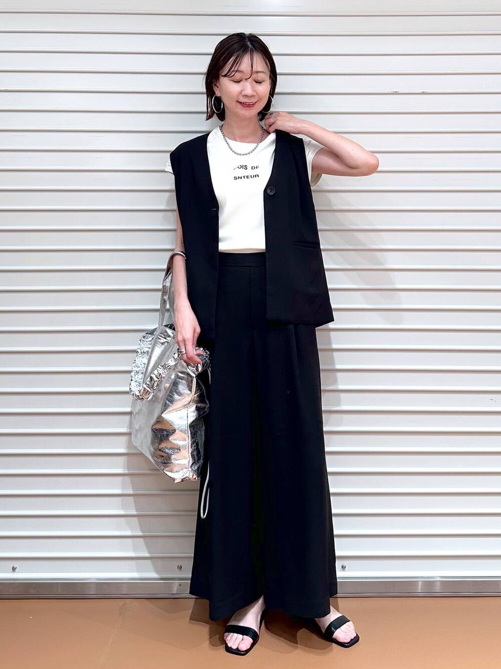 ブラック系のベスト、ホワイト系のTシャツ/カットソー、ブラック系のその他パンツを着用したレディースの夏コーディネートの2枚目の写真