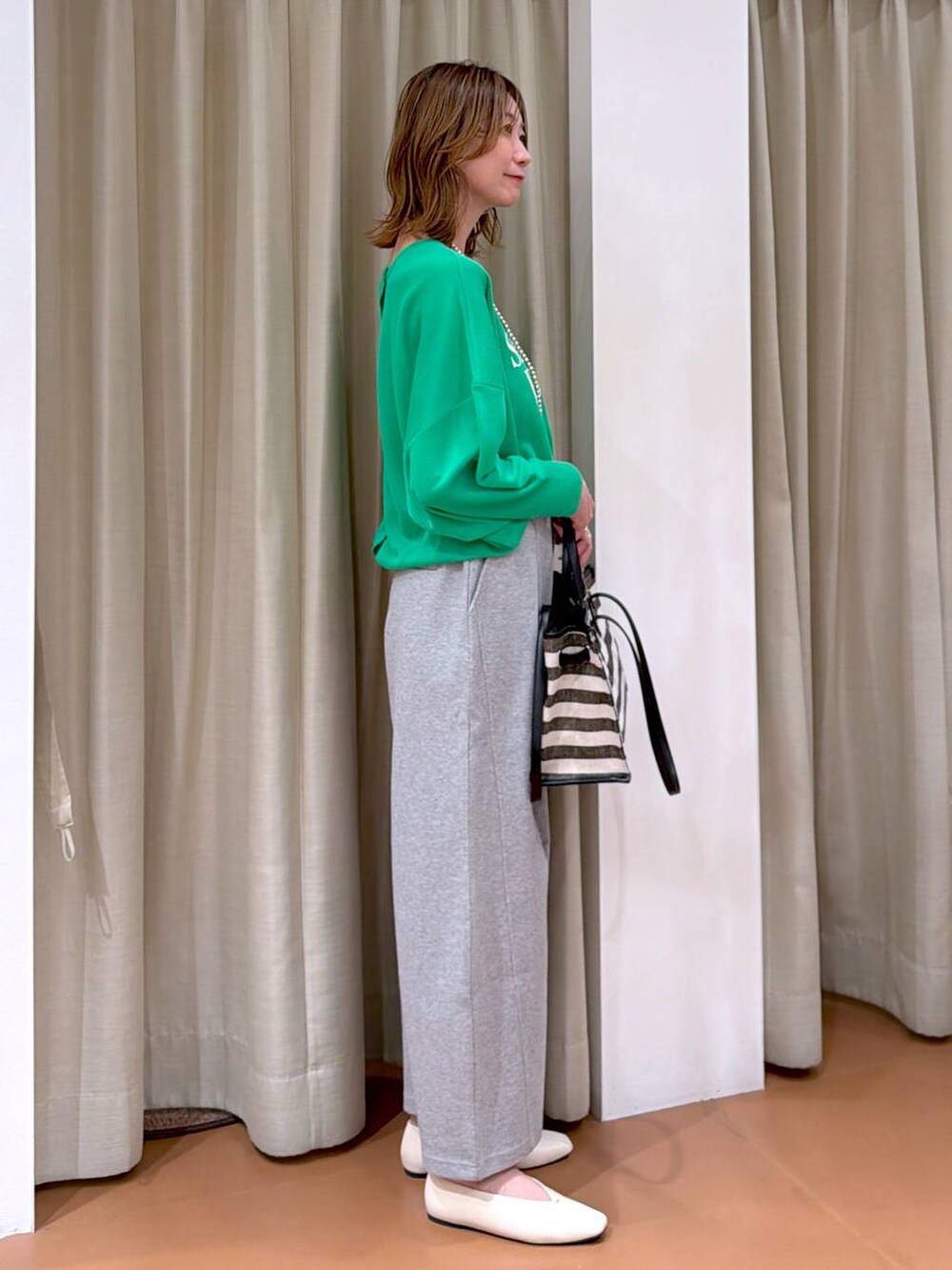 ホワイト系のパンプス、グレー系のスウェットパンツ、ブラック系のトートバッグを着用したレディースの春コーディネートの5枚目の写真