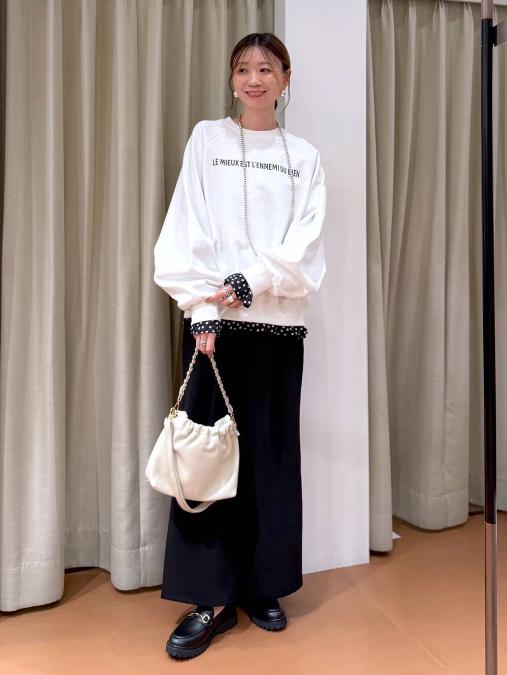 ホワイト系のハンドバッグ、ブラック系のローファー、ブラック系のシャツ/ブラウスを着用したレディースの冬コーディネートの2枚目の写真