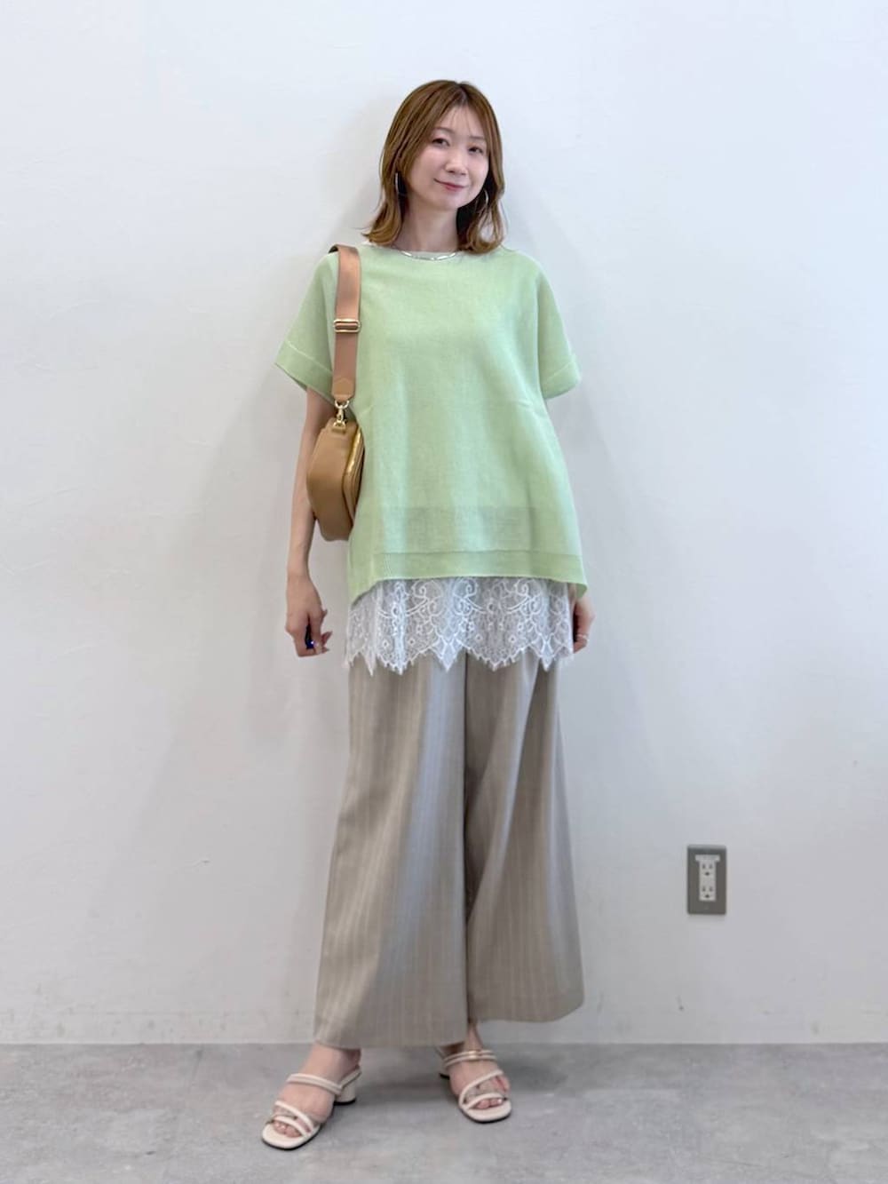 ホワイト系のサンダル、ベージュ系のその他パンツ、ホワイト系のTシャツ/カットソーを着用したレディースの春コーディネートの2枚目の写真