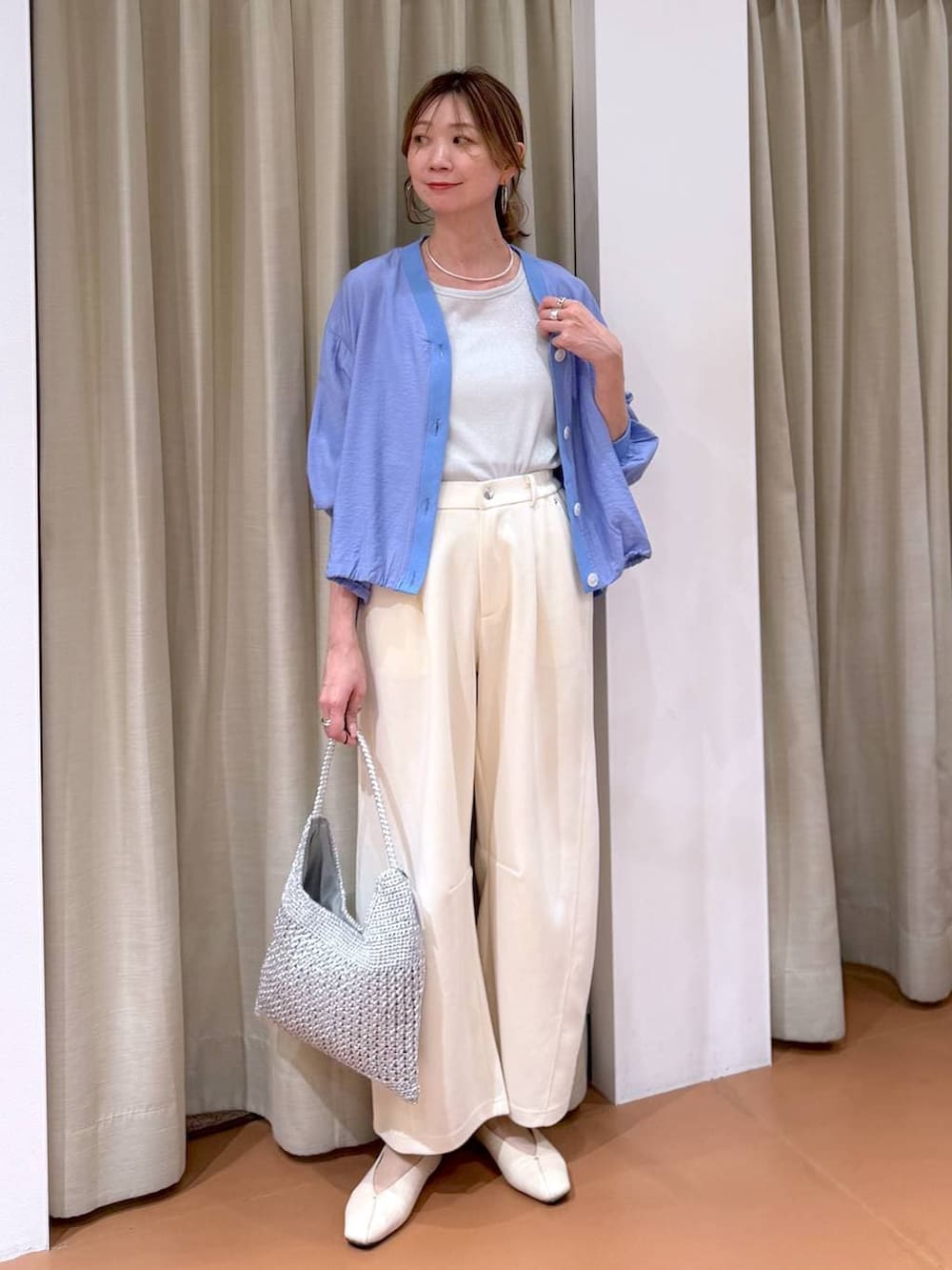 ホワイト系のTシャツ/カットソー、ホワイト系のパンプス、ブルー系のカーディガン/ボレロを着用したレディースの春コーディネートの6枚目の写真
