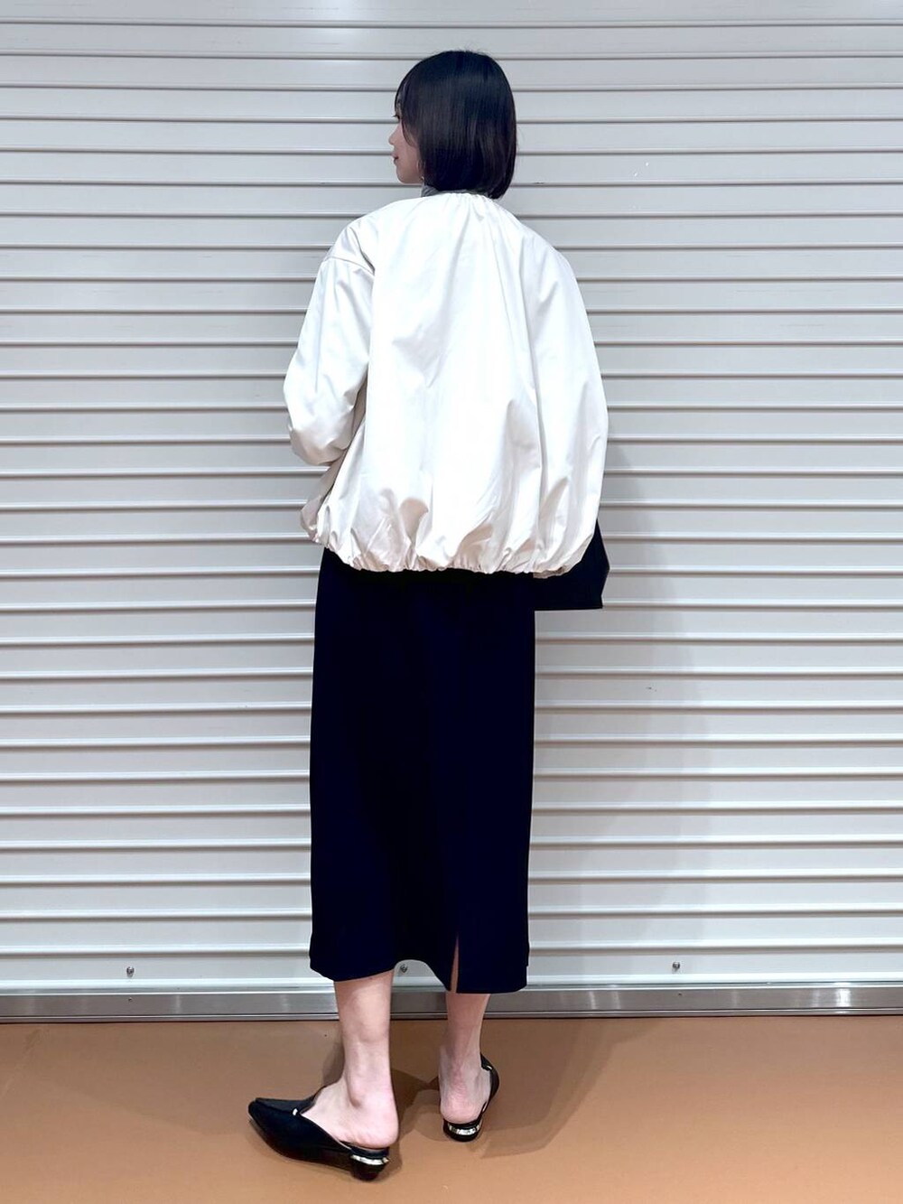 グレー系のTシャツ/カットソー、ブラック系のハンドバッグ、ブラック系のスカートを着用したレディースの冬コーディネートの3枚目の写真