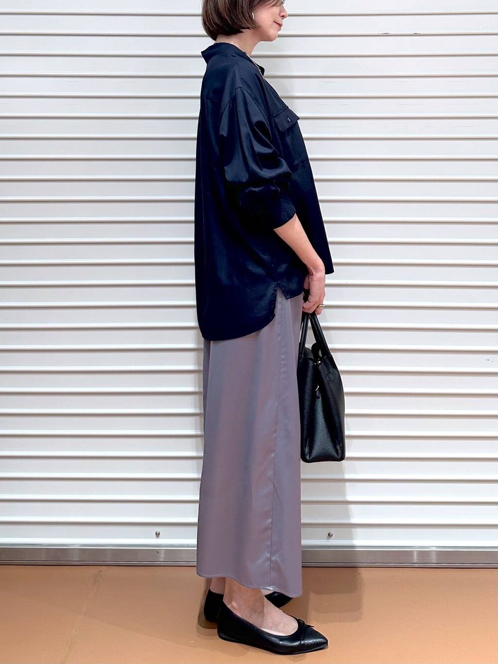 ブルー系のシャツ/ブラウス、ブラック系のパンプス、ブラック系のハンドバッグを着用したレディースの秋コーディネートの6枚目の写真