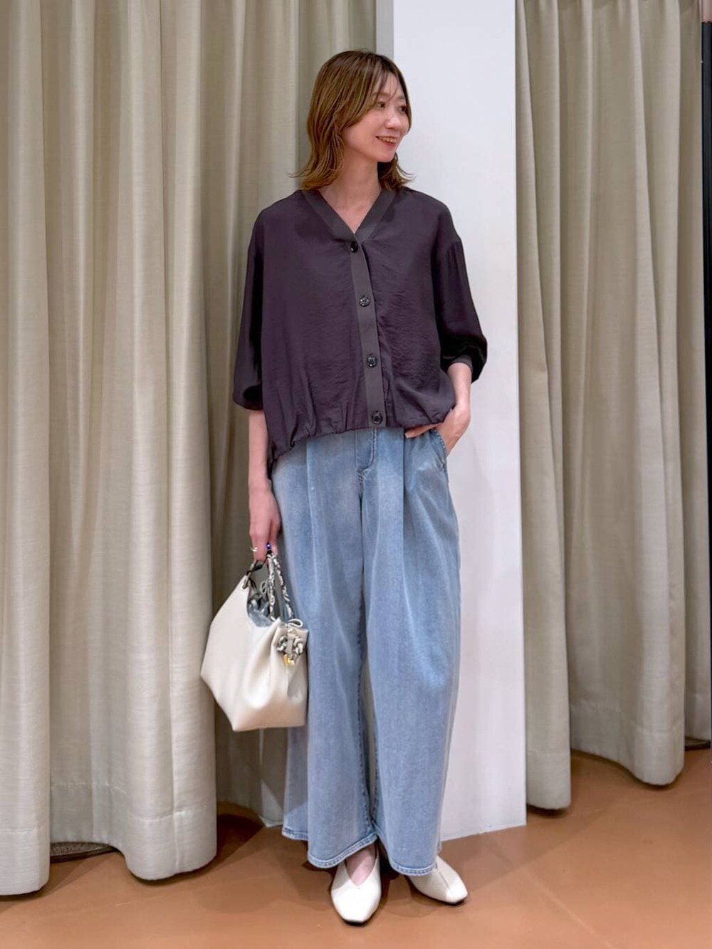 ホワイト系のパンプス、ブルー系のデニムパンツ、ホワイト系のハンドバッグを着用したレディースの春コーディネートの2枚目の写真