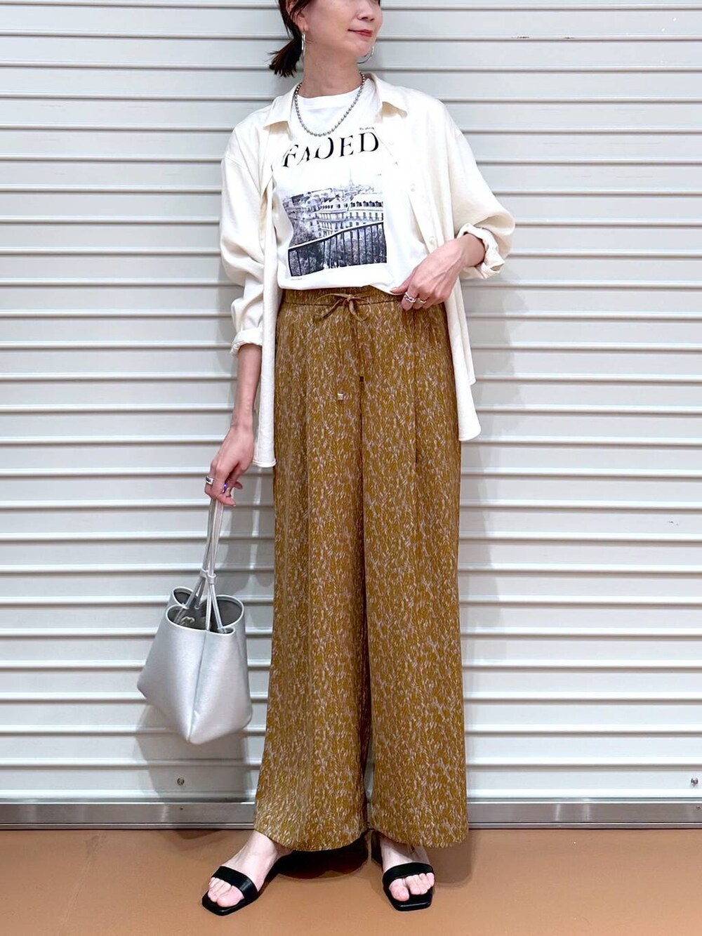 ホワイト系のシャツ/ブラウス、ブラウン系のその他パンツ、ブラック系のサンダルを着用したレディースの夏コーディネートの5枚目の写真