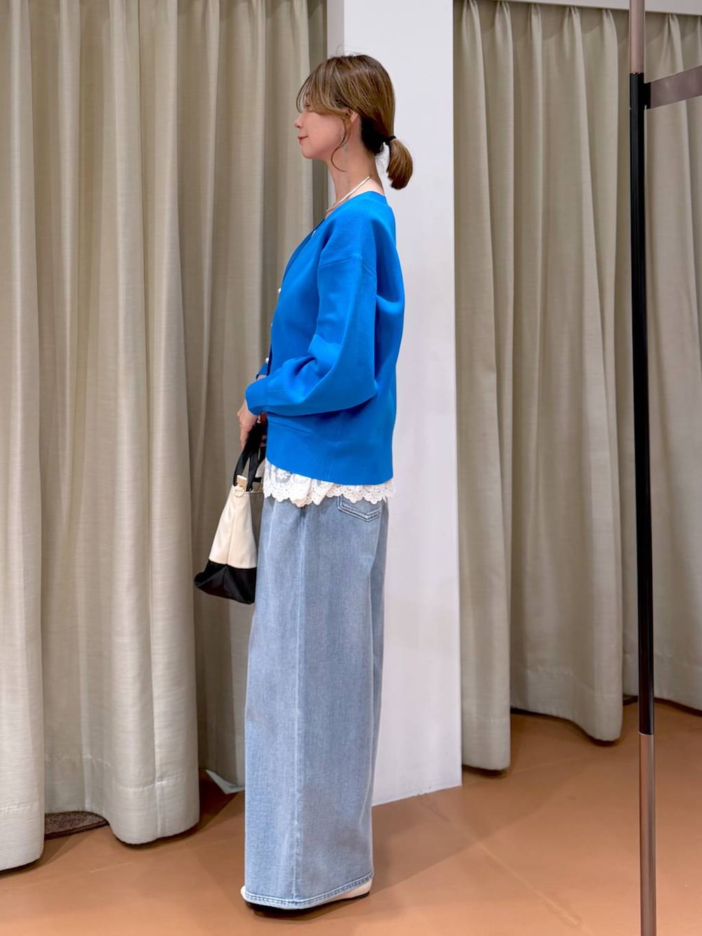 ホワイト系のパンプス、ホワイト系のタンクトップ、ブルー系のデニムパンツを着用したレディースの春コーディネートの3枚目の写真