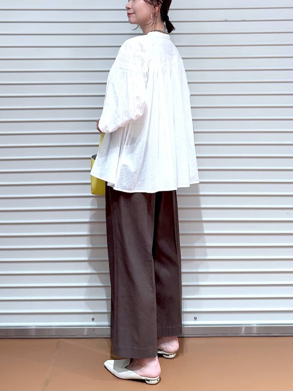 ブラウン系のその他パンツ、ブラウン系のその他パンツ、イエロー系のハンドバッグを着用したレディースの夏コーディネートの6枚目の写真