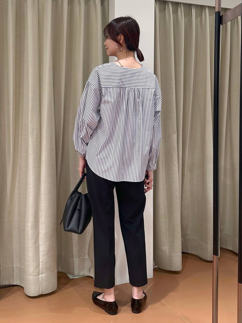 ブラック系のその他パンツ、ブルー系のシャツ/ブラウス、ブラック系のハンドバッグを着用したレディースの春コーディネートの4枚目の写真