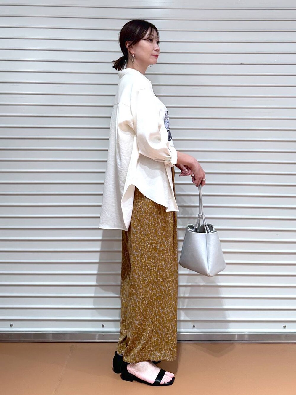 ホワイト系のシャツ/ブラウス、ブラウン系のその他パンツ、ブラック系のサンダルを着用したレディースの夏コーディネートの3枚目の写真