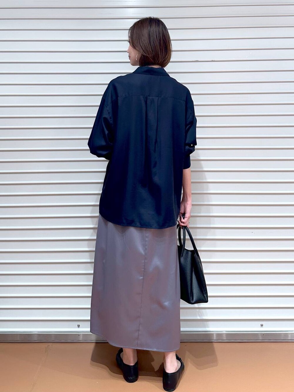 ブルー系のシャツ/ブラウス、ブラック系のパンプス、ブラック系のハンドバッグを着用したレディースの秋コーディネートの4枚目の写真