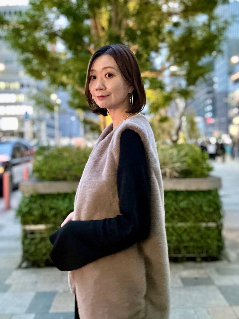 ブラック系のブーツ、ブラウン系のベスト、シルバー系のネックレスを着用したレディースの秋コーディネートの3枚目の写真