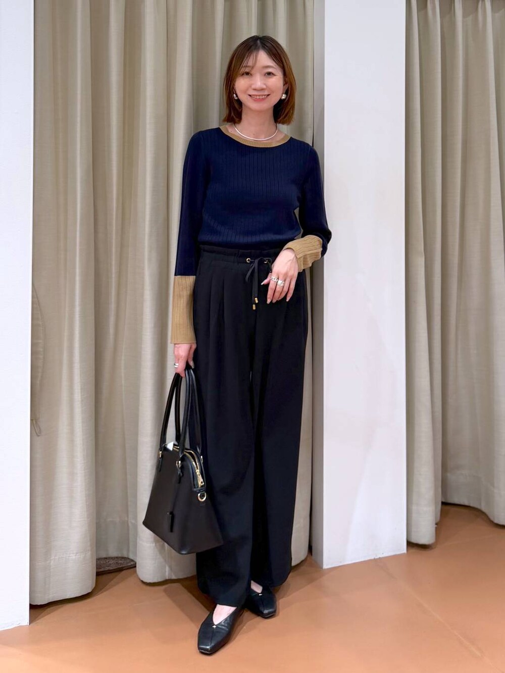 ブラック系のその他パンツ、ブラック系のパンプス、ブルー系のニット/セーターを着用したレディースの冬コーディネートの2枚目の写真