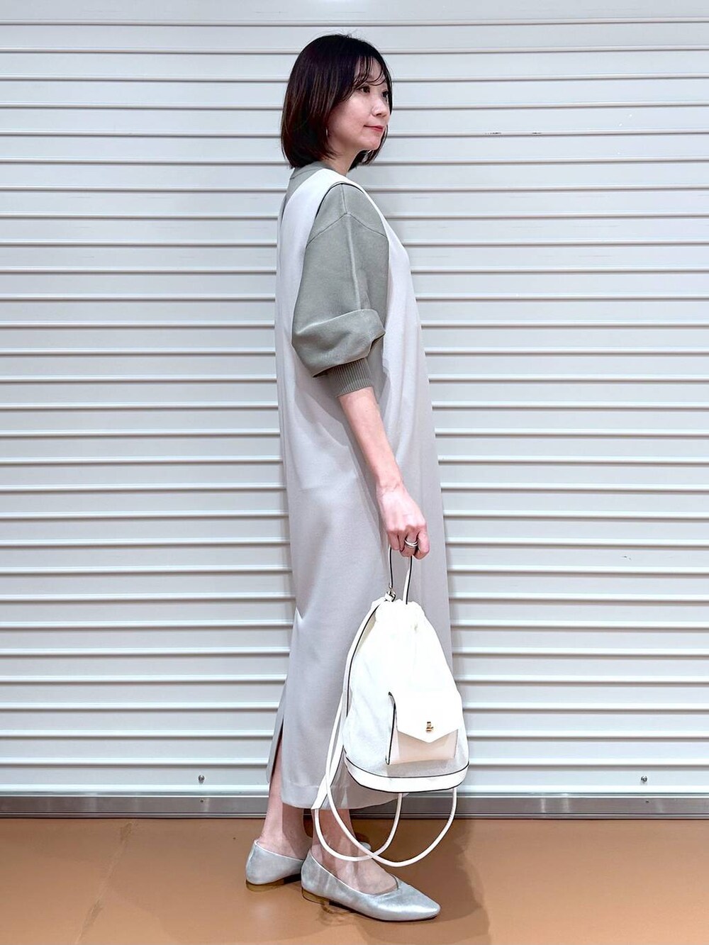ベージュ系のジャンパースカート、ベージュ系のジャンパースカート、シルバー系のパンプスを着用したレディースの夏コーディネートの3枚目の写真