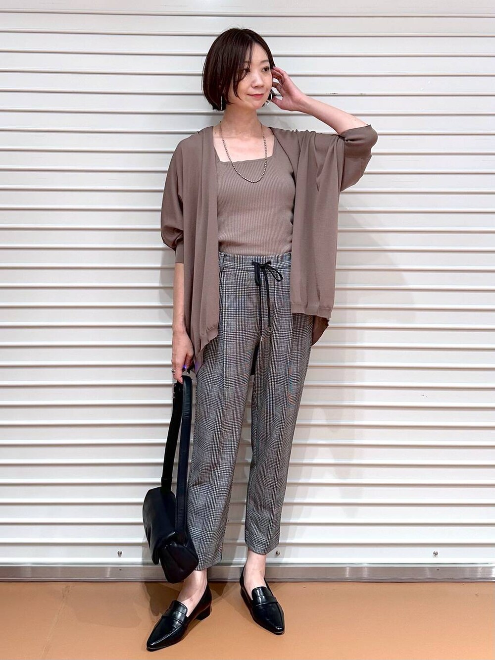 ブラウン系のカーディガン/ボレロ、ブラック系のその他パンツ、ブラウン系のタンクトップを着用したレディースの秋コーディネートの2枚目の写真