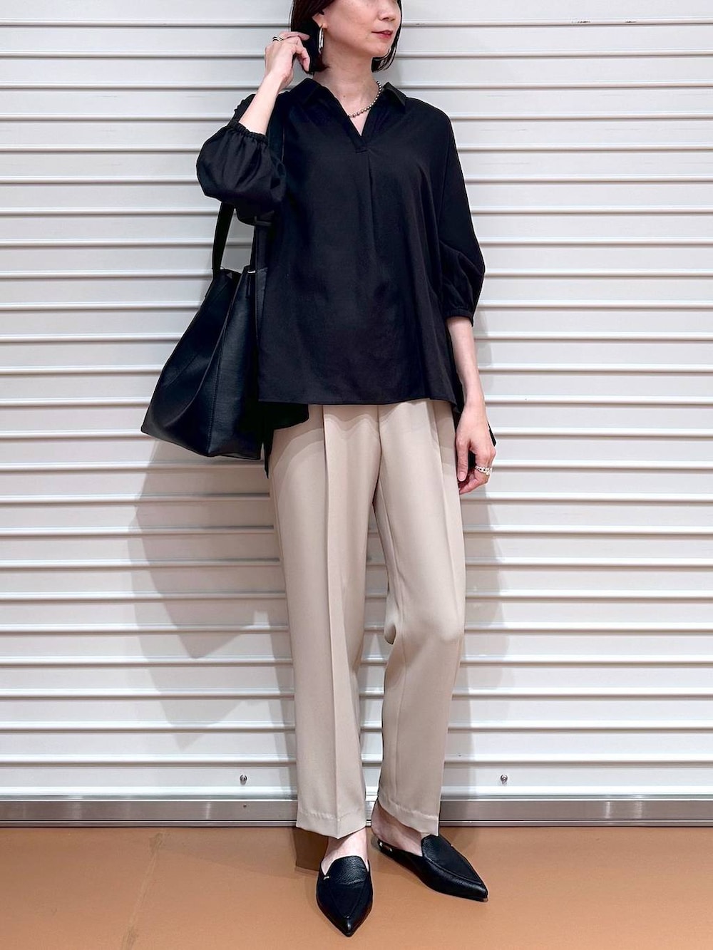 ブラック系のTシャツ/カットソー、ベージュ系のその他パンツ、ブラック系のハンドバッグを着用したレディースの春コーディネートの5枚目の写真