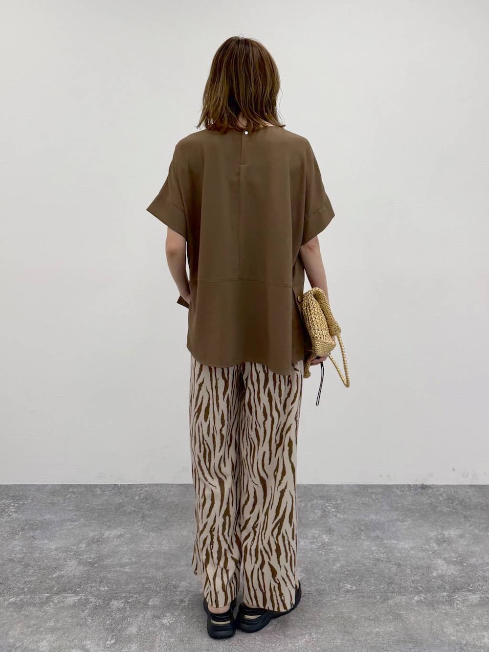 ゴールド系のトートバッグ、その他のその他パンツ、ブラウン系のTシャツ/カットソーを着用したレディースの春コーディネートの4枚目の写真